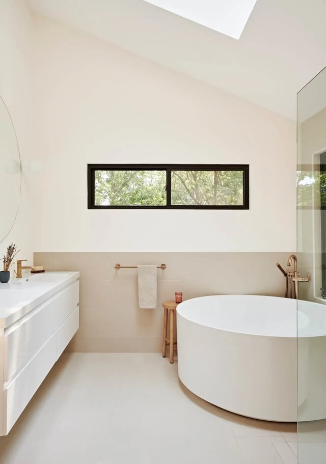 Modern bathroom with round tub and floating vanity.