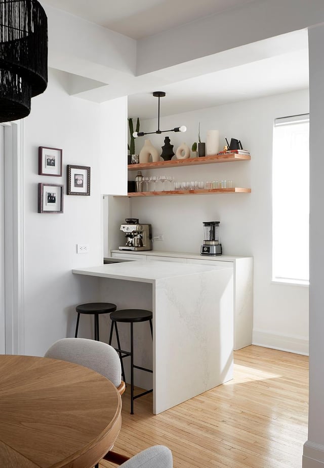 modern dining corner with white walls, ceiling, counter and light wood flooring and open shelves