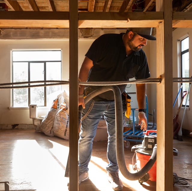 General contractor in a gut renovation with walls stripped down to the studs