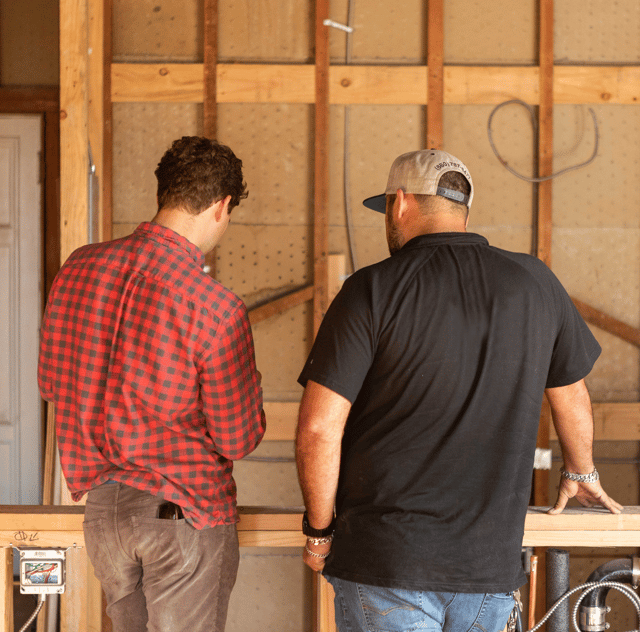 A homeowner and contractor talking in a space under renovation
