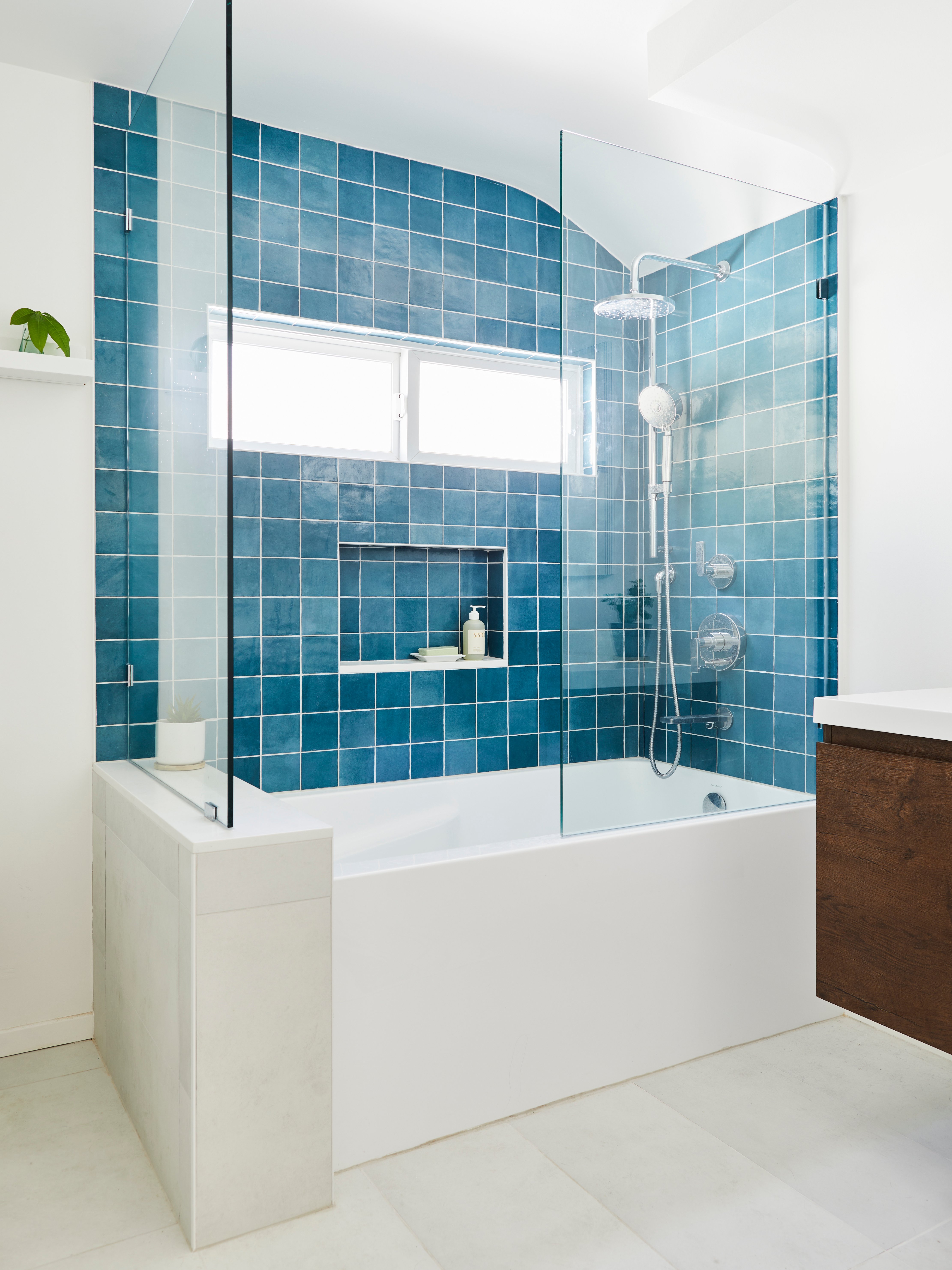 LA bathroom remodel with a tub-shower combo with aqua blue wall tiles, a glass enclosure, and nickel fixtures