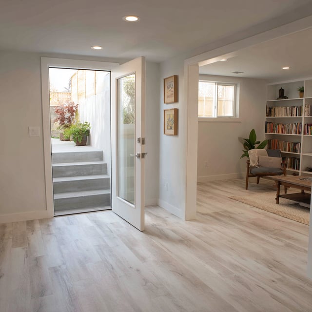 Finished basement room with open door and outdoor stairs.