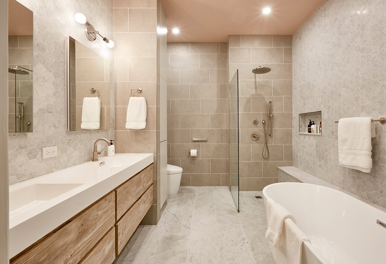 Primary bathroom with large soaking tub, walk-in shower, double vanity, nickel fixtures, a blush pink ceiling, and grey tiles