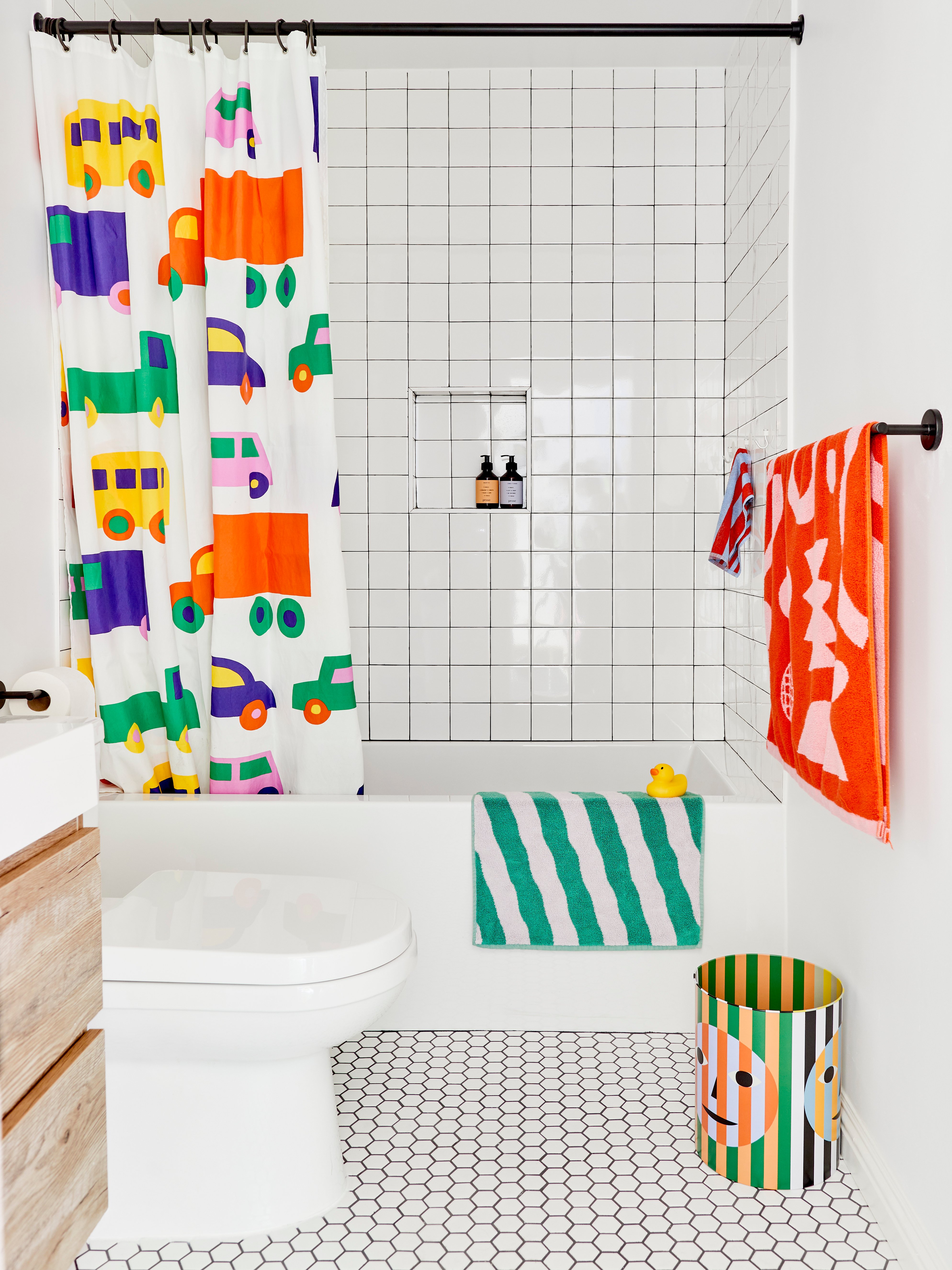 Los Angeles children's bathroom with colorful patterned decor and accessories like a shower curtain, towels, and bath mat