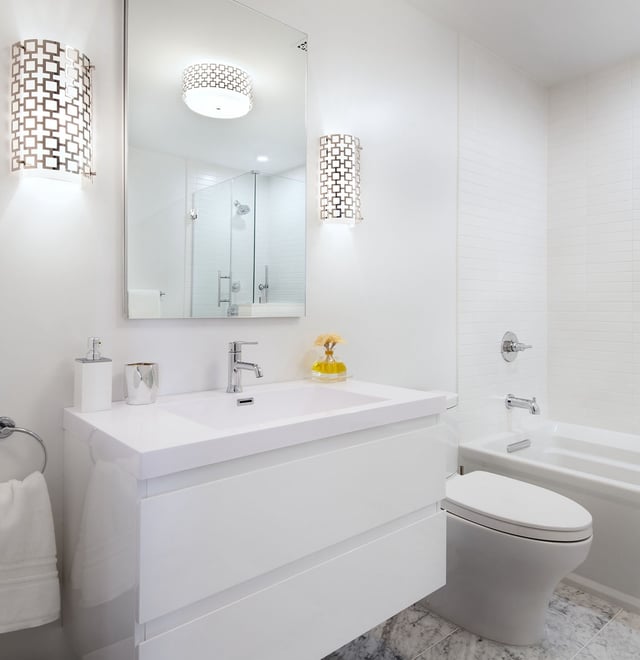 White bathroom with floating vanity, wall scones and flush mount, marbled floor tile, and subway tile walls