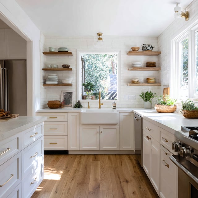 Bright bungalow kitchen with white cabinets and wood shelves.