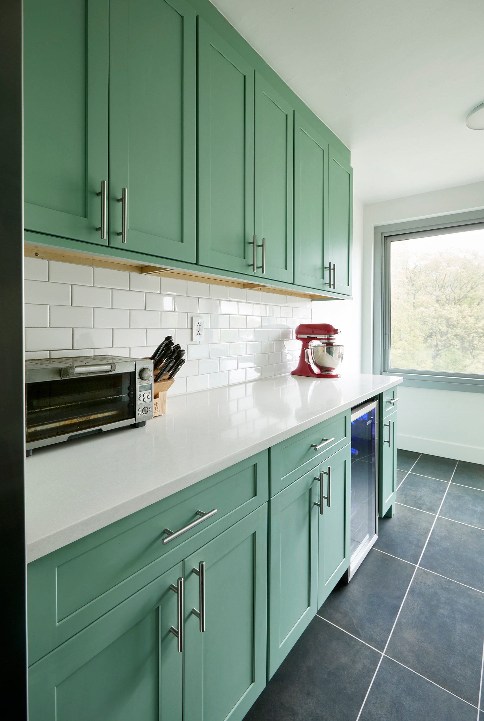 Green cabinets with classic brick subway tiles
