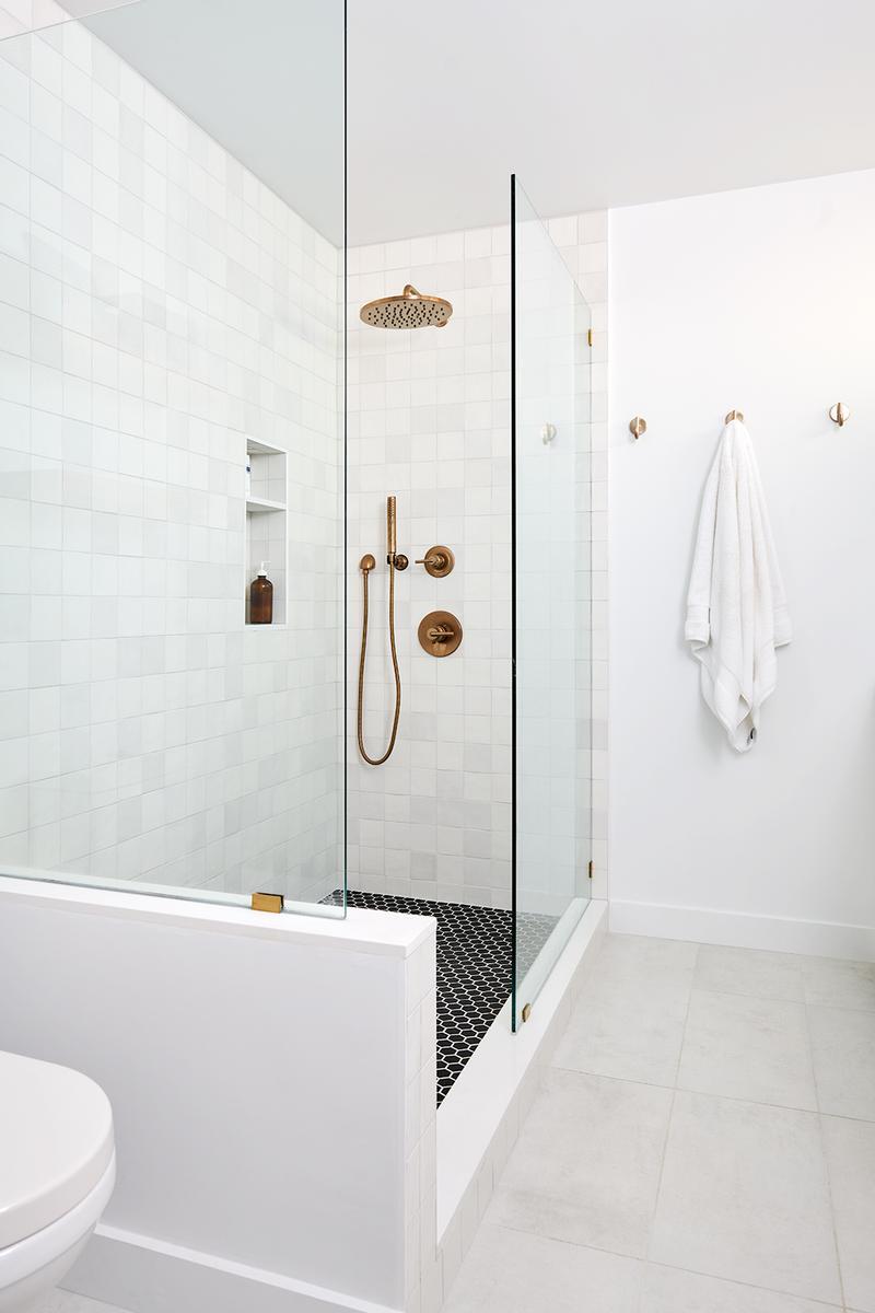white tiled shower gold fixtures