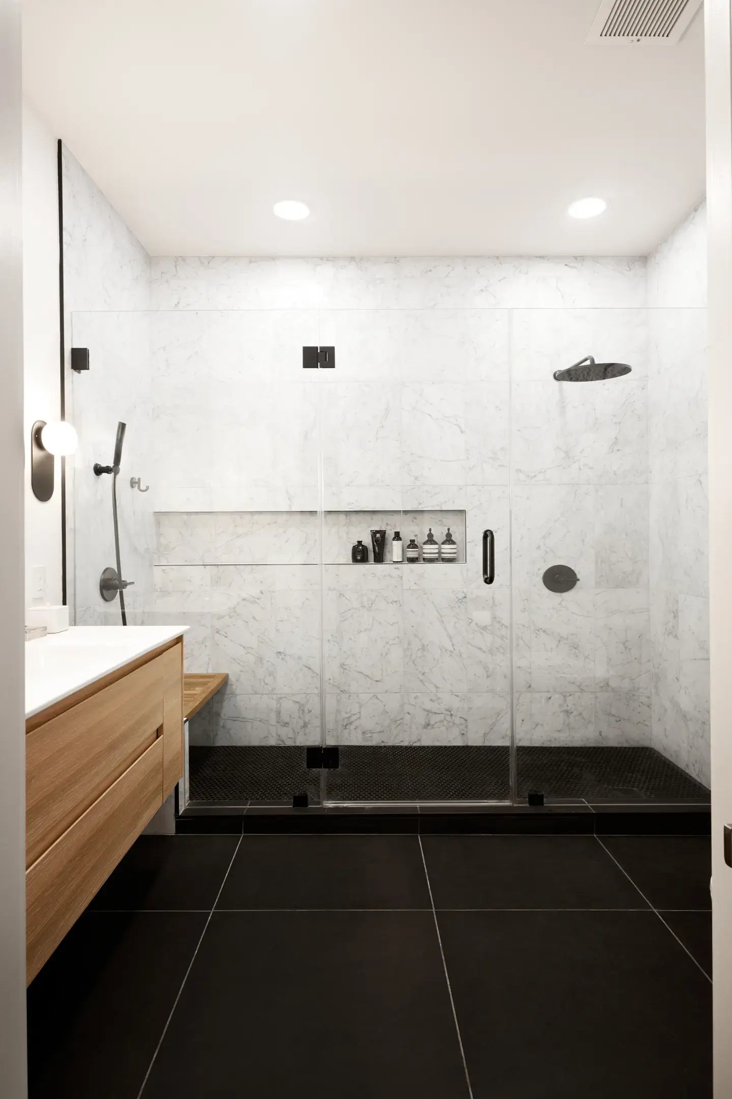 Black floors and black appliances with white marble bathroom