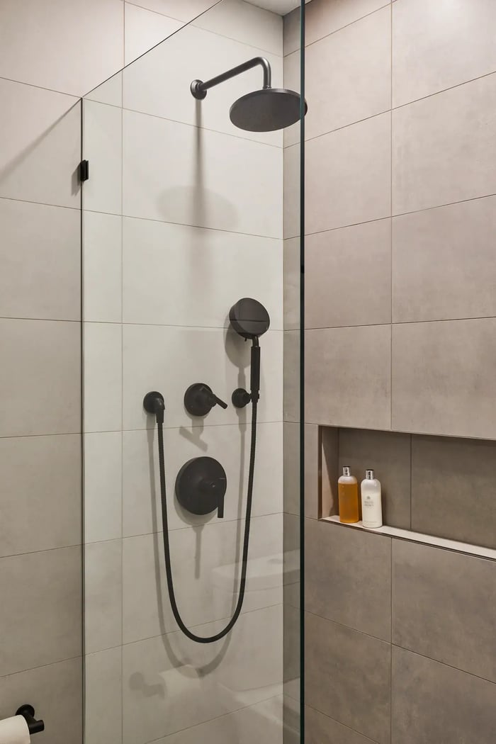 Stone walled shower black appliances