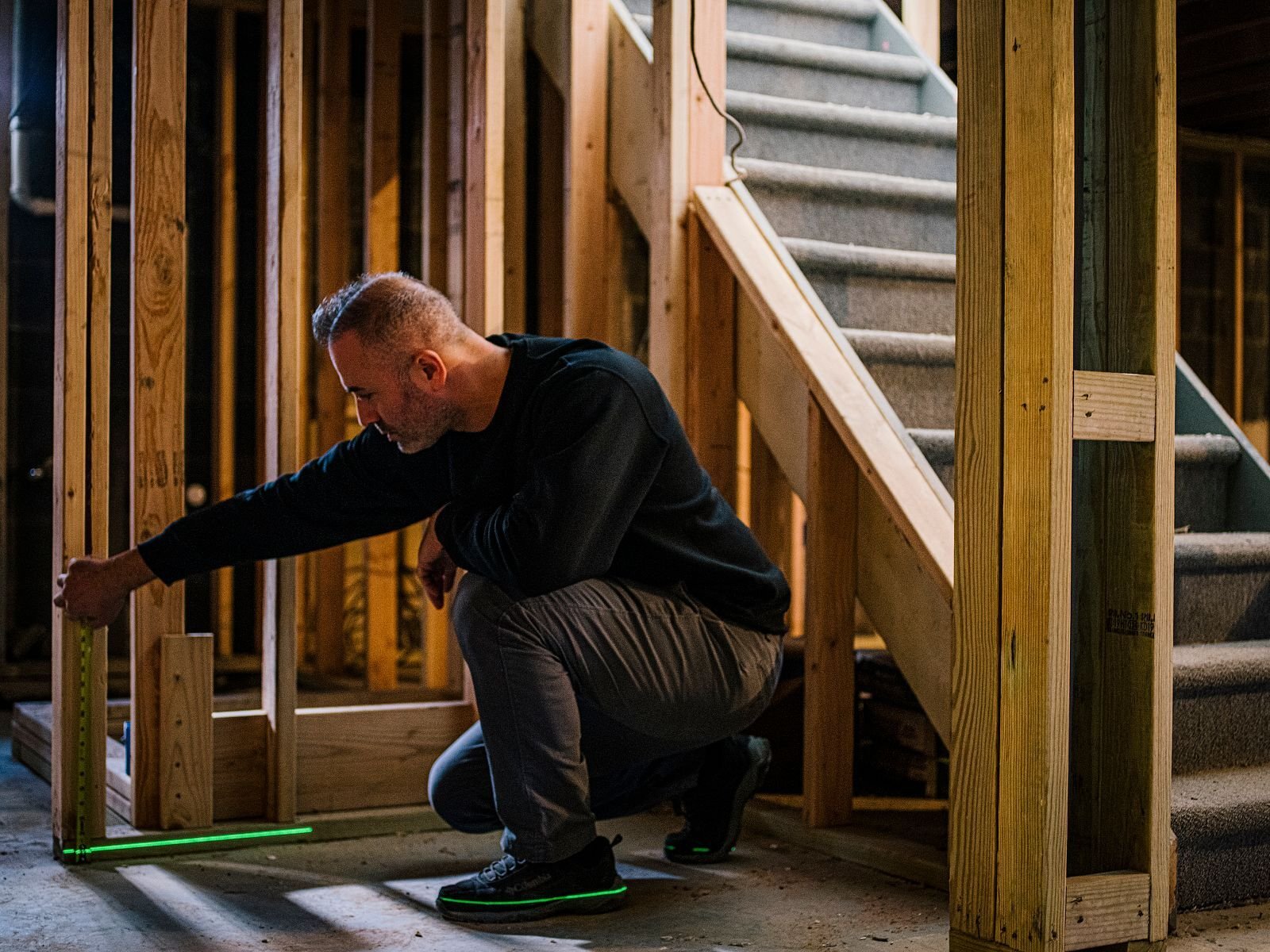 Man measuring space to build in-law suite