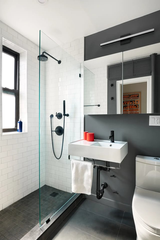 Modern bathroom with grey walls, subway tile, and black trim.