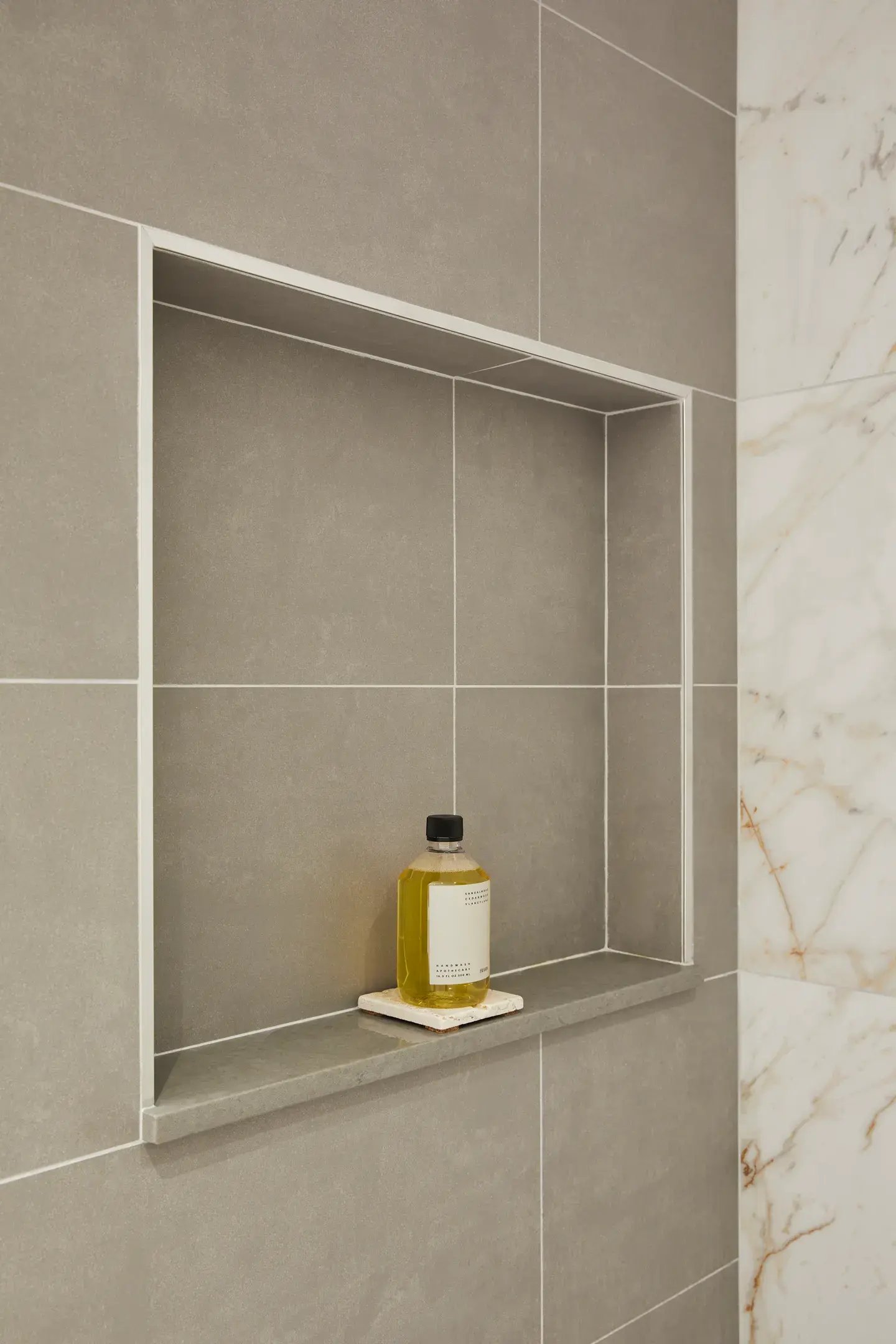 Minimalist shower wall featuring a built-in recessed niche with clean tile trim, providing sleek, clutter-free storage that enhances both function and modern shower design.