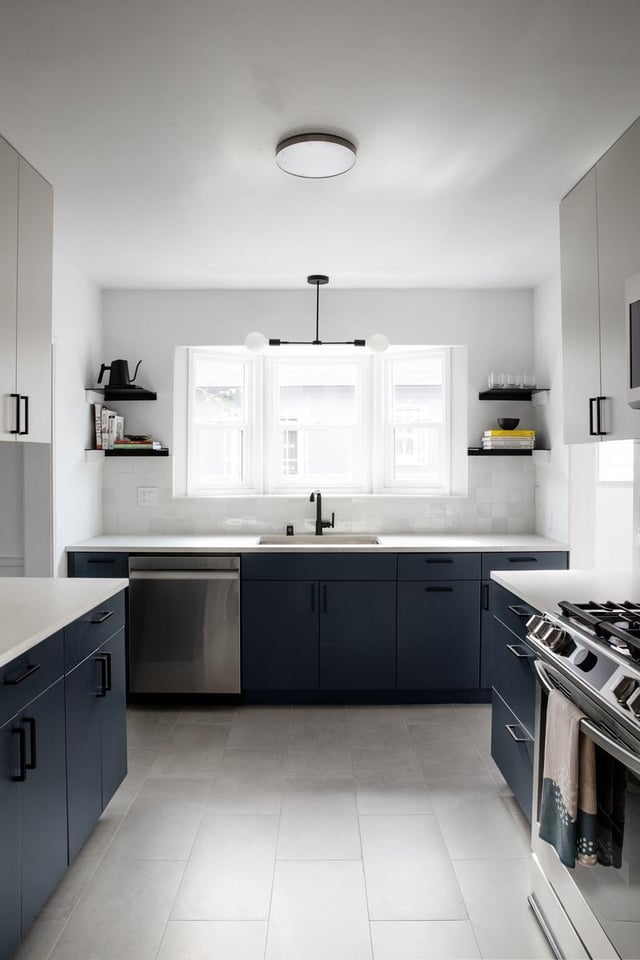 Modern kitchen with blue cabinets and white countertops.