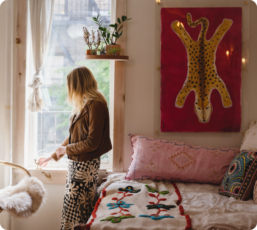 Bohemian bedroom with embroidered duvet, patterned pillows, and wall art.