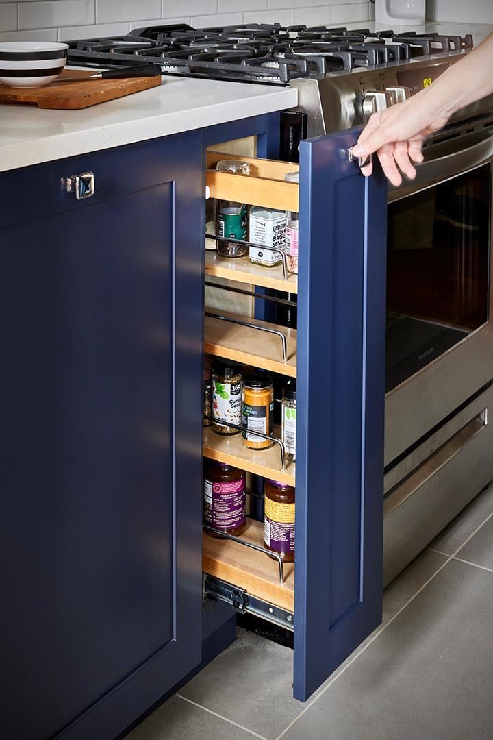 A pull-out spice rack, a clever storage solution designed to maximize efficiency in a modern kitchen.