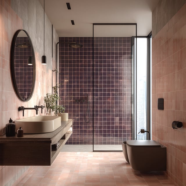 A modern bathroom featuring pinkish-red subway tiles, a floating dark wood vanity with a vessel sink, and a shower with dark purple tiled walls enclosed by a glass panel.