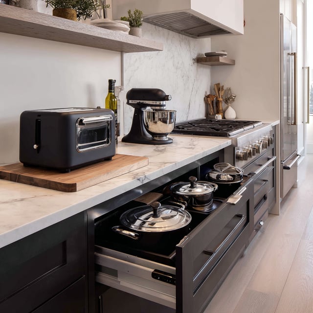 Modern kitchen with open drawer showing pots and pans.