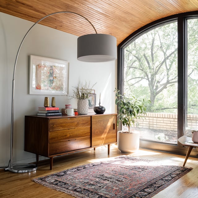 Mid-century modern room with wood ceiling and arched lamp.