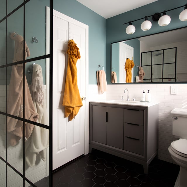 Completed bathroom renovation with large storage vanity and glass shower wall