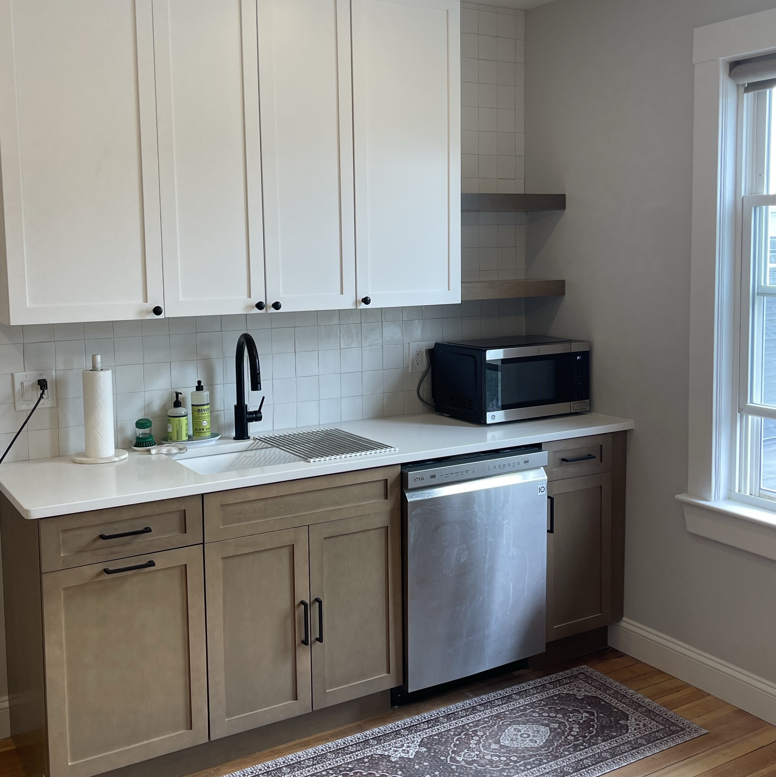 Traditional design Boston kitchen after remodel by general contractor, with white and wood cabinets plus matte black fixtures and hardware